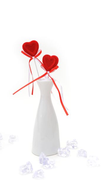 Два красных плюшевых сердца в белой вазе
 - Фото, изображение