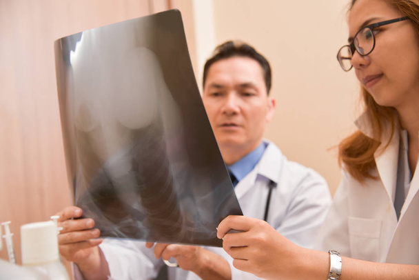 Asian doctors examining x-ray film of a patient. - Φωτογραφία, εικόνα