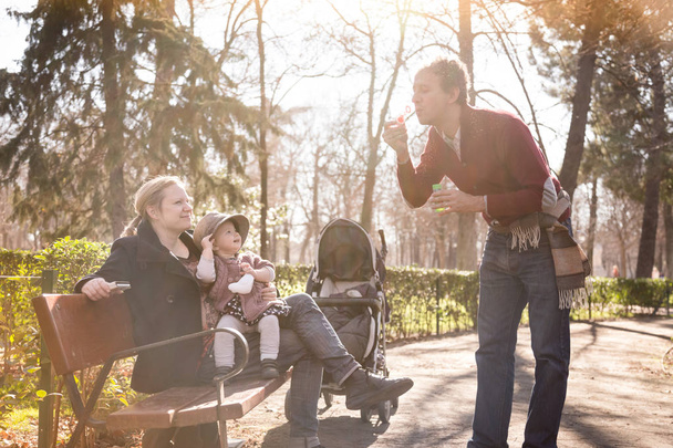 Junge Familie mit fröhlichem Kind im Park. - Foto, Bild