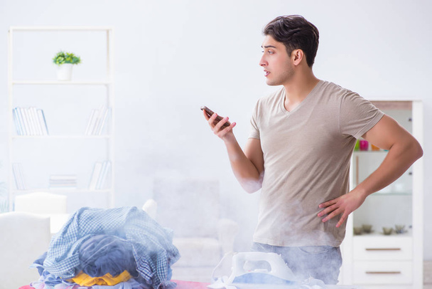 Απρόσεκτος σύζυγος καίει ρούχα, ενώ σιδέρωμα - Φωτογραφία, εικόνα