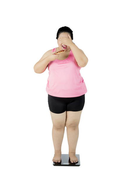 Obese woman standing on the weighing scale - Foto, imagen