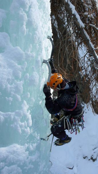 alpiniste masculin escalade de glace sur une cascade gelée en hiver dans les montagnes de Suisse
 - Photo, image