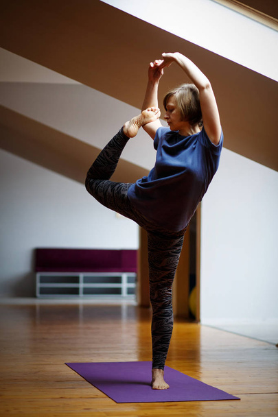 Una atleta hace increíbles ejercicios de yoga en el gimnasio
. - Foto, Imagen
