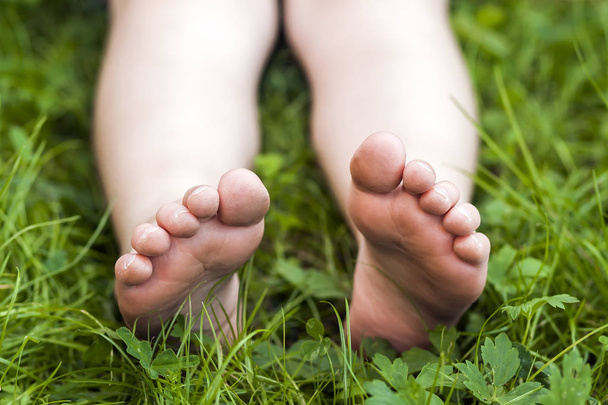 Gros plan des pieds de petite fille sur l'herbe verte
 - Photo, image