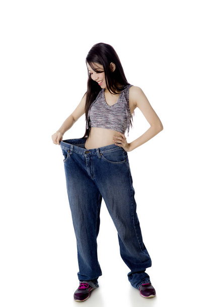 Chinese woman wearing her old jeans on studio - 写真・画像