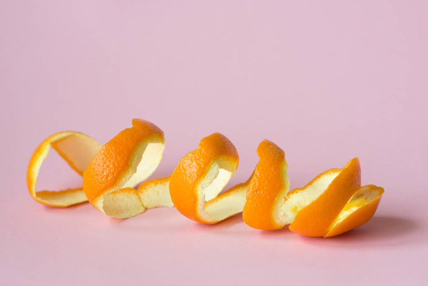 skórka pomarańczowa na różowym tle, jako symbol recyklingu krążyć gospodarki - Zdjęcie, obraz