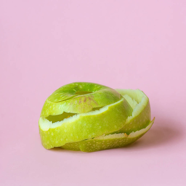 buccia di mela verde su sfondo rosa come simbolo di riciclaggio circolare economia
 - Foto, immagini