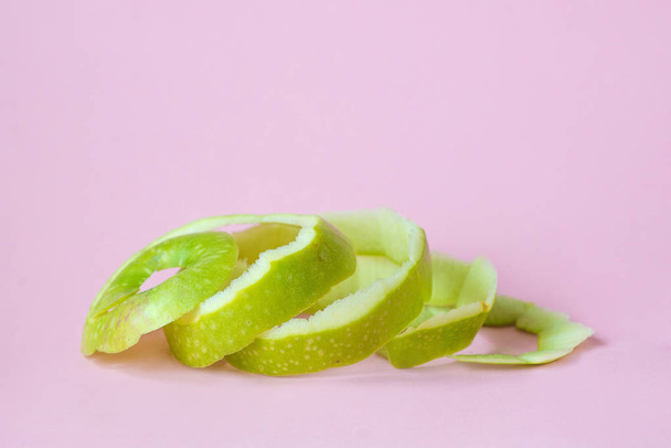 green apple peel on pink background as a symbol of recycling circulate economy - Fotografie, Obrázek