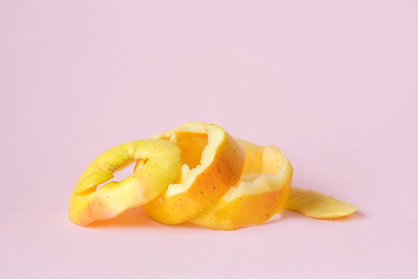 cáscara de manzana amarilla sobre fondo rosa como símbolo de reciclaje circular economía
 - Foto, imagen