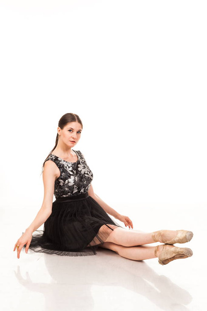schöne junge Ballerina, isoliert auf weißem Hintergrund. in Spitze und schwarzem Balletttutu. sitzt auf dem Bindfaden, zeigt verschiedene Posen. anmutige Brünette mit langen Haaren. - Foto, Bild