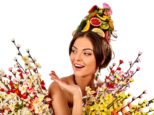 Μάσκα μαλλιών από φρέσκα φρούτα στο κεφάλι γυναίκας και ανοιξιάτικα λουλούδια. - Φωτογραφία, εικόνα
