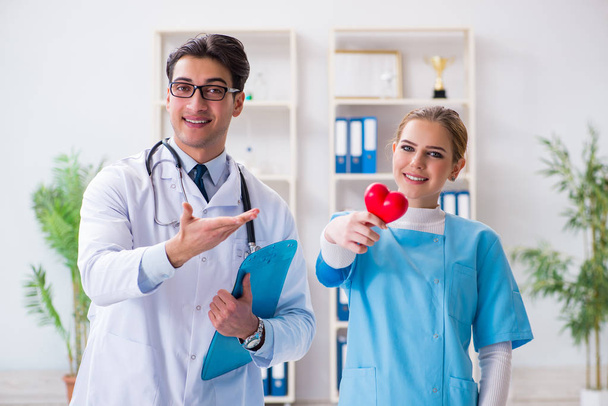 Cardioloog met zijn verpleegster assistent poseren in ziekenhuis - Foto, afbeelding