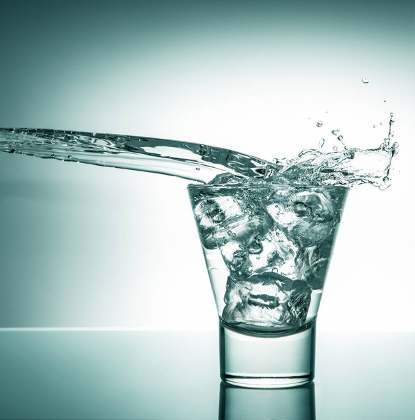 glass with ice and liquid splash - Foto, afbeelding