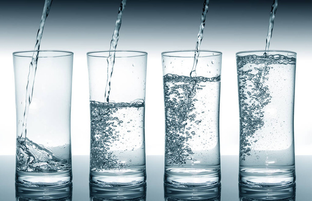 Water filling glasses in sequence - Photo, Image