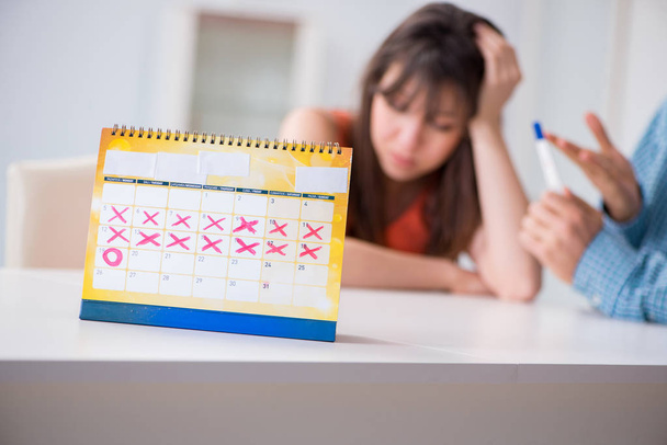 Jong gezin in zwangerschap planning concept met ovulatie kalender - Foto, afbeelding