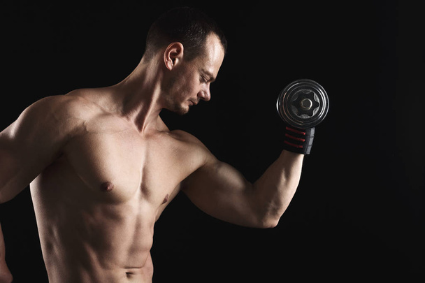 Ισχυρή Αθλητικός άνδρας με αλτήρα showes γυμνή μυώδες σώμα - Φωτογραφία, εικόνα