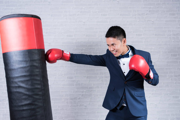 man wearing suit and boxing gloves on gray background - Φωτογραφία, εικόνα