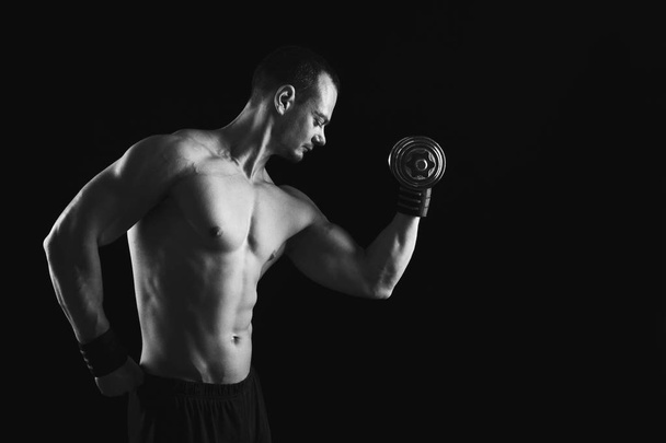 Vahva urheilullinen mies käsipaino näyttää alasti lihaksikas elin
 - Valokuva, kuva