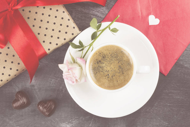 Espresso coffee in a white cup, a pink rose, a gift with a red t - Фото, зображення