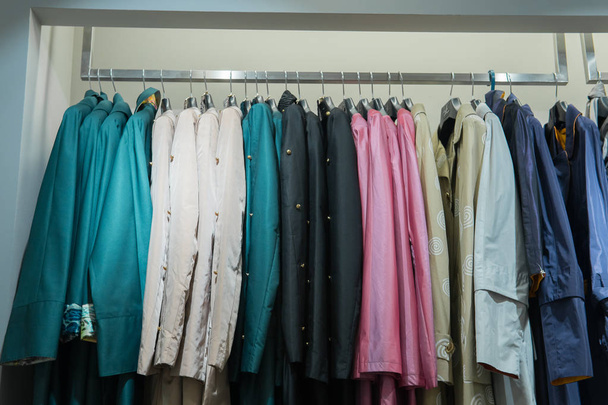 Řádek z podzimních kabátů zavěšených na stojanu, nákupní - Fotografie, Obrázek