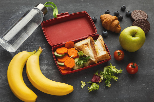 Lunchbox mit gesundem Essen auf schwarzem Tischhintergrund - Foto, Bild