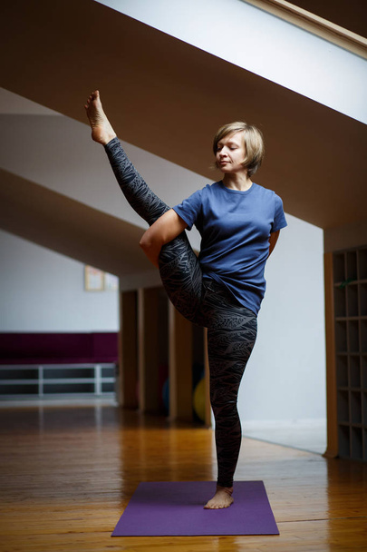 Uma bela jovem a treinar no ginásio. Pose de prática de Yoga de mulher
. - Foto, Imagem