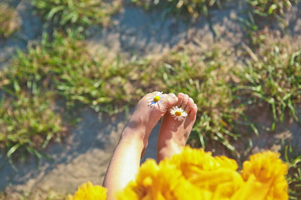 sun flowers chamomile girl little skirt holds fingers  - Фото, изображение