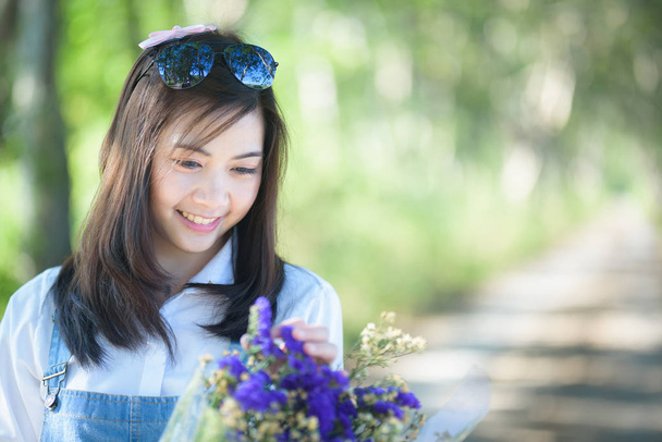 Portret van mooi meisje met bloemen op groene achtergrond - Foto, afbeelding