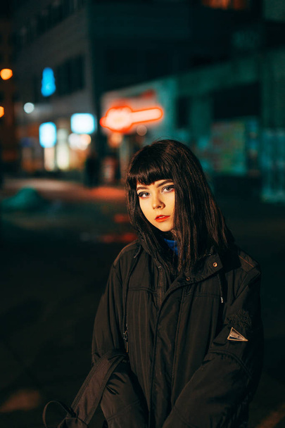 Young Japanese girl stand near neon lights and pose to the camer - Foto, Imagem