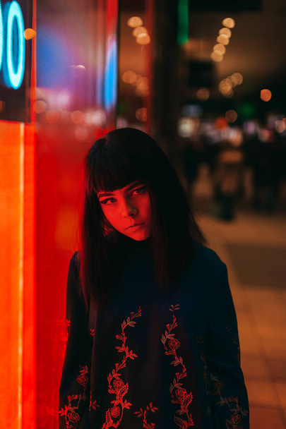 Young Japanese girl stand near neon lights and pose to the camer - Fotografie, Obrázek