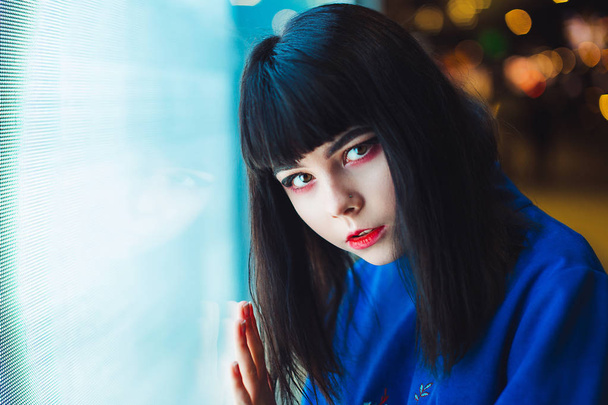 Young Japanese girl stand near neon lights and pose to the camer - Фото, зображення