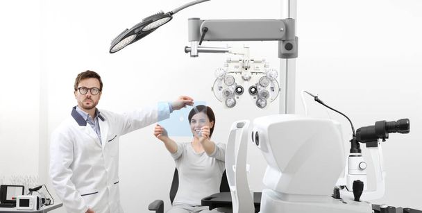 optometrist examining eyesight woman patient pointing at the hol - Photo, Image