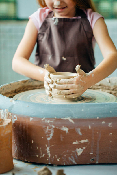 Hands of young potter, close up hands made cup on pottery wheel - Φωτογραφία, εικόνα