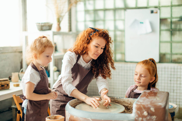 mother and two redhead daughters made clay cup with pottery wheel - 写真・画像