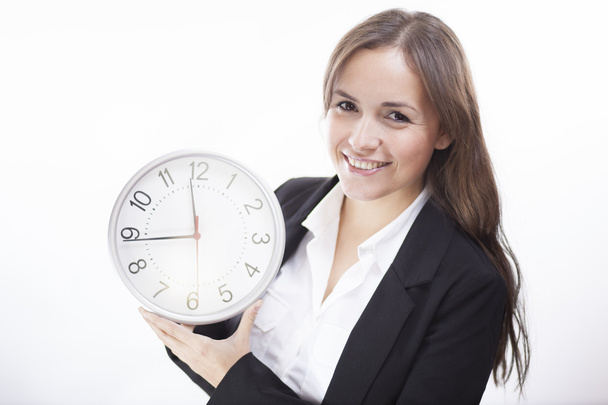 Pretty smiling brunette woman holding a clock - Foto, Bild
