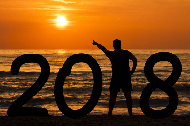 Sylwetka człowieka formowania rok 2018 wskazuje się słońce o świcie w  - Zdjęcie, obraz