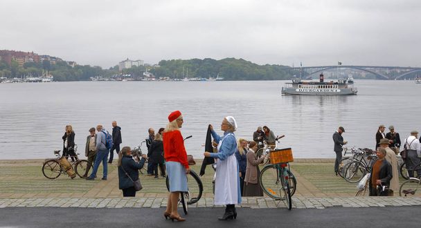STOCKHOLM - SEPT 23, 2017: Senior women dressed as old fashioned nurses holding retro bicycles in the Bike in Tweed event September 23, 2017 in Stockholm, Sweden - Photo, image