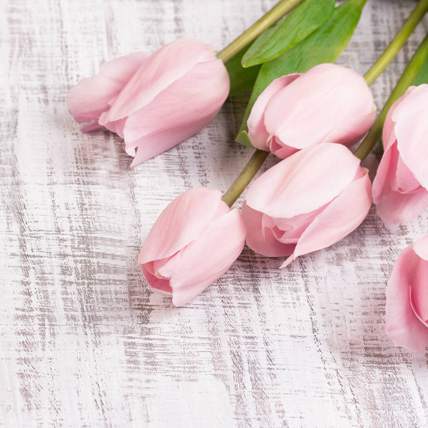 Fresh pink tulip flowers bouquet on white wooden rustic table. View with copy space - Fotoğraf, Görsel