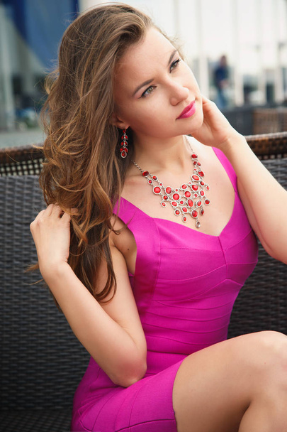 Portrait of a beautiful young woman in bright fashion dress in a summer restaurant - Фото, зображення
