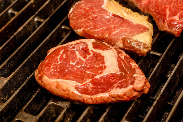 The chef cooks steaks on the grill. - Foto, Imagen
