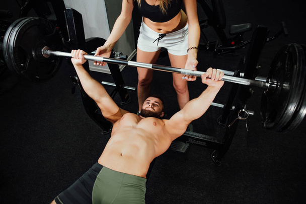 young sexy beautiful fitness couple is exercising in the gym. the instructor is exercising. - Zdjęcie, obraz