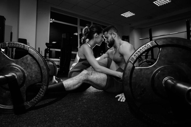 young sexy beautiful fitness couple is exercising in the gym. the instructor is exercising. - Foto, Imagen