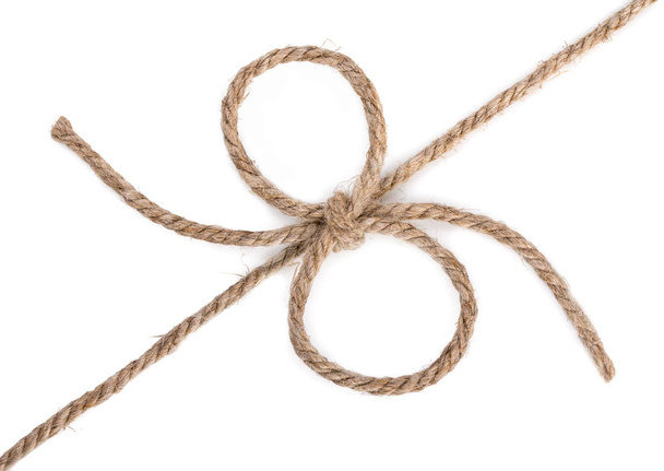 grobes Seil und ein Bogenknoten, isoliert auf weißem Hintergrund, in der Nähe - Foto, Bild