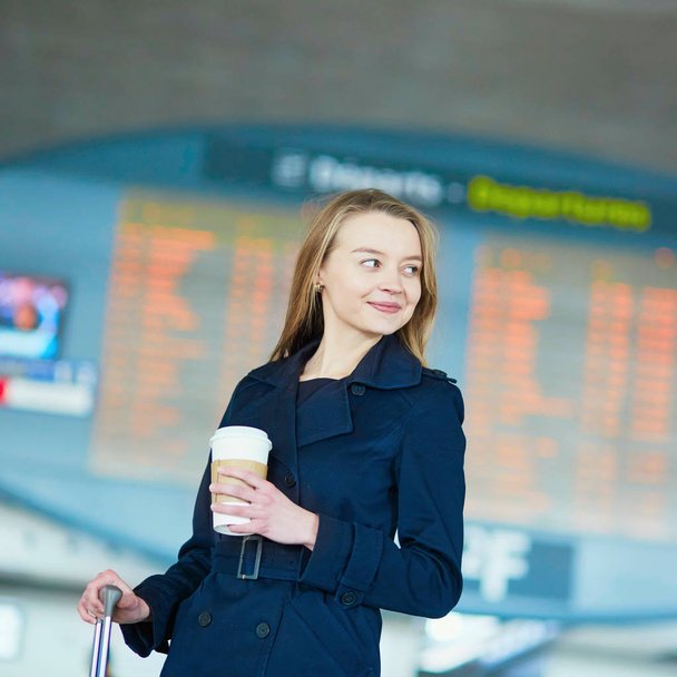 Young woman in international airport near large information display - Photo, Image