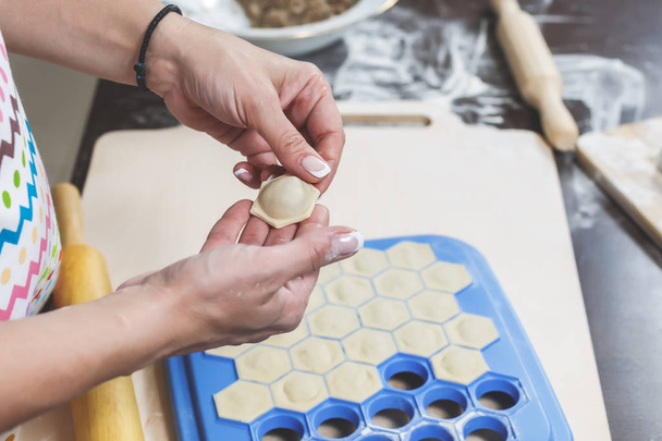 Le processus de fabrication de délicieuses boulettes maison. Les mains féminines tiennent fraîchement boulettes sur le fond de l'espace de travail de la cuisine
 - Photo, image