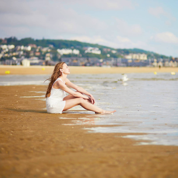 Beautiful young woman enjoying her vacation by ocean or sea. People on sea vacation concept - Foto, immagini