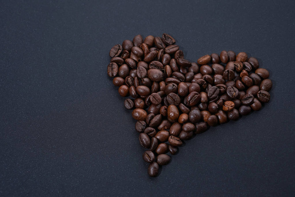 Coração feito de grãos de café no fundo escuro
 - Foto, Imagem