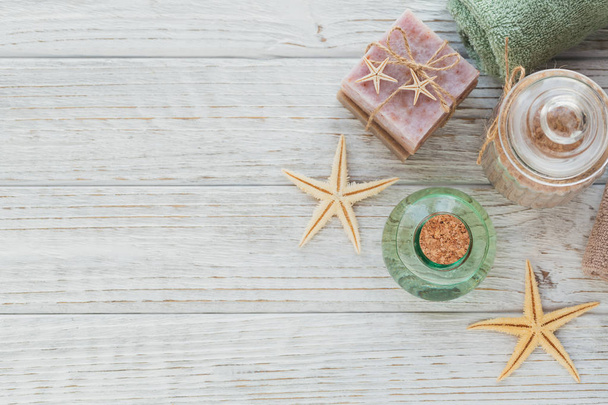 Spa products for facial and body care. Natural sea salt, homemade soap, massage oil and colorful towels. Spa and bodycare concept. Top view with copy space for text - 写真・画像
