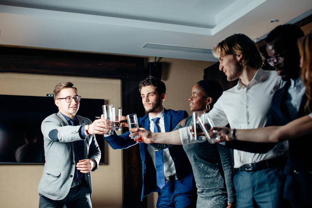 business people clinking glasses and smiling while celebrating in meeting - Fotoğraf, Görsel