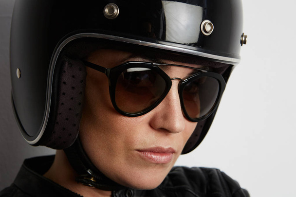Young woman in motorcycle concept. In bike helmet on white background with free space for advertising - Фото, зображення